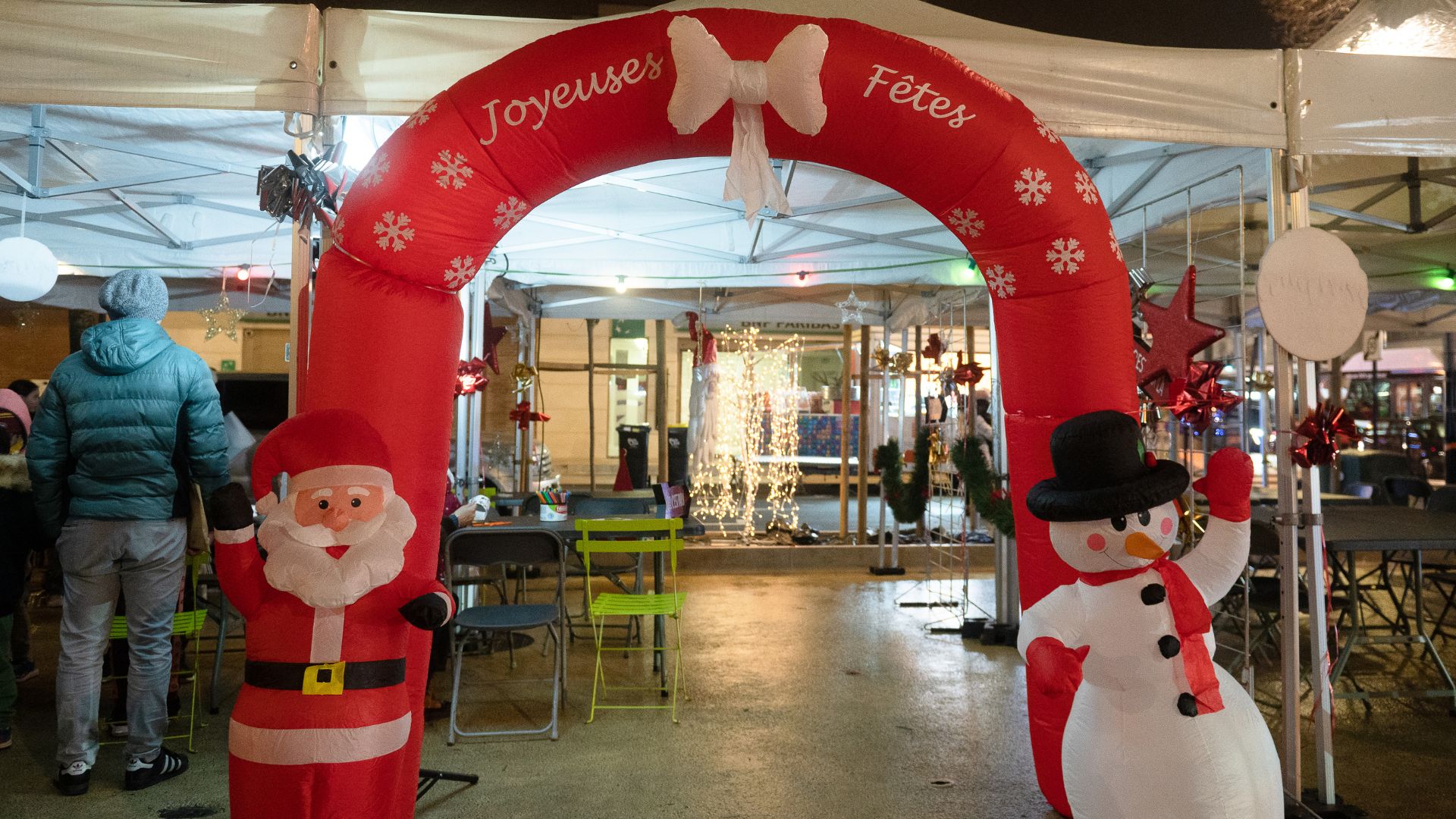 Photo du marché de Noël avec un boudin gonflable sur lequel est écrit Joyeuses fêtes